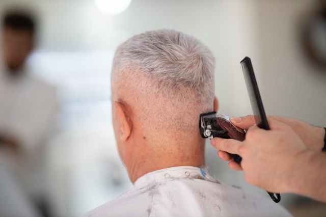 person using hair razor on man s hair