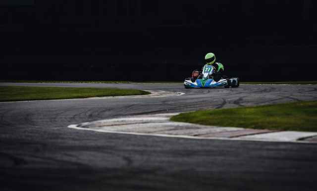 man wearing green helmet riding go kart